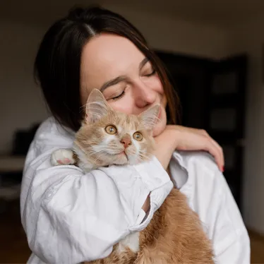 woman hugging cat